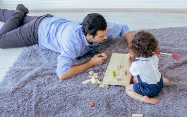 Father playing toys with his little daughter at home