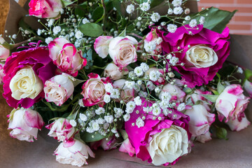 Bouquet of white-pink roses lying on the table