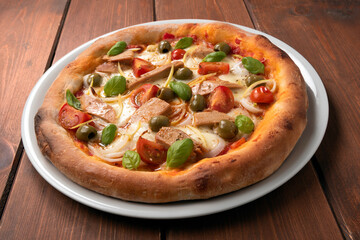 Deliziosa pizza gourmet con tonno pinne gialle, cipolle, pomodorini, olive e basilico fresco 