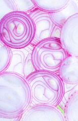 Top view of back lighted onion slices,Background of red onion rings lying next to each other isolated on white background