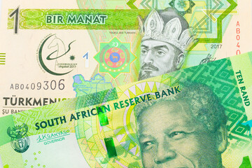 A macro image of a shiny, green 10 rand bill from South Africa paired up with a green and yellow one manat note from Turkmenistan.  Shot close up in macro.