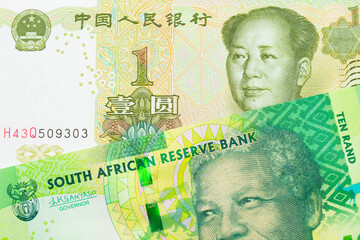 A macro image of a shiny, green 10 rand bill from South Africa paired up with a green and white one yuan note from China.  Shot close up in macro.