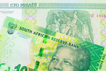 A macro image of a shiny, green 10 rand bill from South Africa paired up with a green one hundred ruble note from Belarus.  Shot close up in macro.