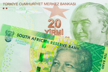 A macro image of a shiny, green 10 rand bill from South Africa paired up with a green, twenty Turkish lira bank note.  Shot close up in macro.