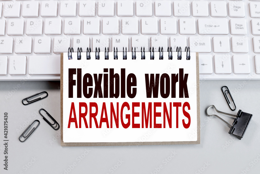 Poster flexible work arrangements. text on white notepad paper on white keyboard on gray background