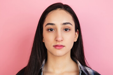 Caucasian woman's portrait isolated on coral pink studio background with copyspace