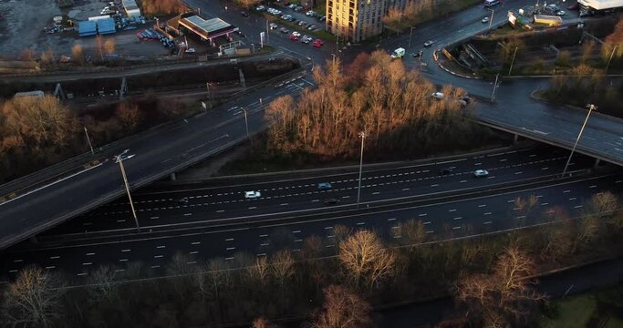 Aerial tracking shot of ambulance passing over busy highway and through junctions at sunset, Glasgow