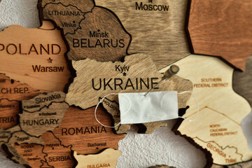 Ukraine on a wooden map and a medical mask.the inscription of a world pandemic. covid-19