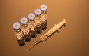 Vials with COVID-19 vaccine and a syringe with a needle for injection against coronavirus...