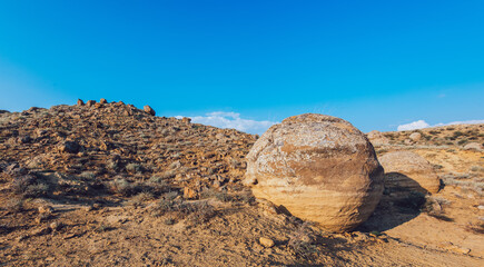 Fototapeta na wymiar Big round boulder among rocky formations