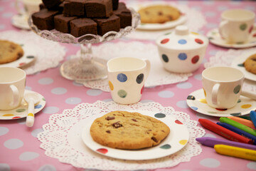 Children's party table, with cookie, chocolate brownies cups  and coloring crayons