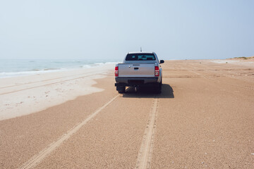 Fototapeta na wymiar Car on empty beach near sea