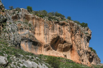 Fototapeta na wymiar Colorful hard limestone cliffs and caves in Nahal [stream] Aviv deep canyon, east of Upper Galilee, Northern Israel, South of Lebanon border, Israel.