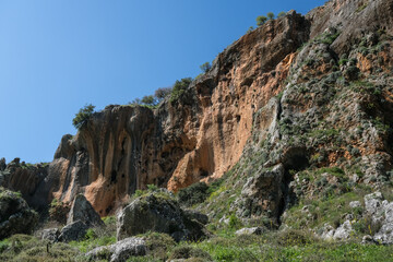Colorful hard limestone cliffs and caves in Nahal [stream] Aviv deep canyon, east of Upper Galilee, Northern Israel, South of Lebanon border, Israel.