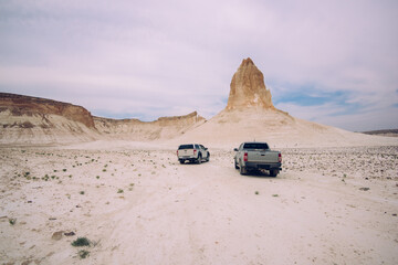 Cars driving along sandy desert area