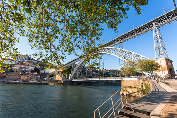 Obraz premium Riverfront and huge double-deck metal arch bridge in historical city Porto