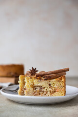 Two pieces of apple pie with cinnamon on a plate, light concrete background. Semolina cake with apple and spices. Homemade mannik.