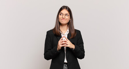 young business woman scheming and conspiring, thinking devious tricks and cheats, cunning and...