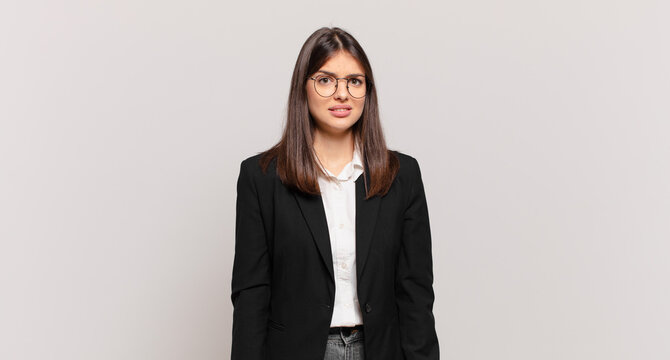 young business woman feeling puzzled and confused, with a dumb, stunned expression looking at something unexpected