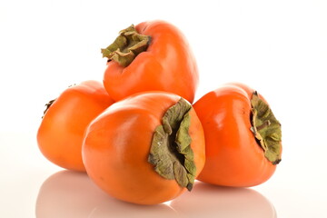 Four juicy persimmons, close-up isolated on white.