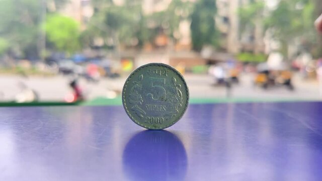 A Five rupees Indian Currency coin kept on table with Indian street background in Depth of Field, Business, finance, industrial conceptual background video