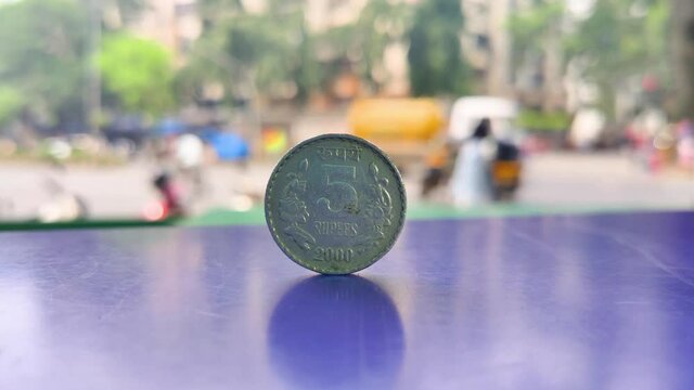 A Five rupees Indian Currency coin kept on table with Indian street background in Depth of Field, Business, finance, industrial conceptual background video