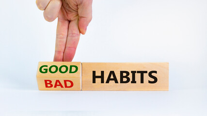 Good habits symbol. Businessman turns a wooden block and changes words 'bad habits' to 'good habits'. Beautiful white background. Business, psychological and good or bad habits concept. Copy space.