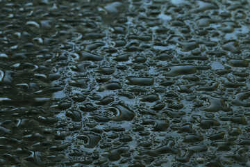 Water drops on a glass surface with reflection