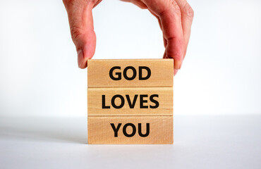 God loves you symbol. Concept words 'God loves you' on wooden blocks on a beautiful white background, prayer hand. Copy space. Religion and God loves you concept.