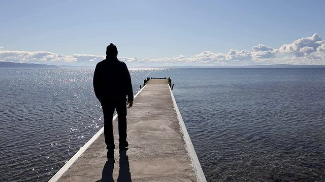 Visingso, Sweden A man walks out on a dock in Lake Vattern on a sunny day. 