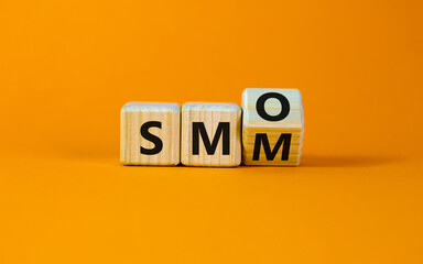 SMM vs SMO symbol. Turned a cube and changed words 'SMM, social media marketing' to 'SMO, social media optimization'. Business, SMM vs SMO concept. Beautiful orange background, copy space. - obrazy, fototapety, plakaty