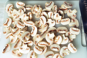 sliced mushrooms on a chopping wooden board close-up.