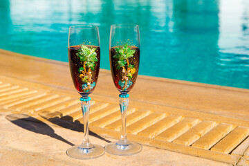 Two glasses with wine on the table. Summer cafe terrace on the beach. Relax by the pool with wine . Vacation time