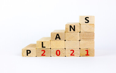 Business concept of 2021 new year plans. Wooden blocks with words 'Plans 2021'. Beautiful white...