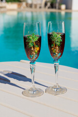 Two glasses with wine on the table. Summer cafe terrace on the beach. Relax by the pool with wine . Vacation time