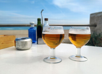 Disfrutando de dos cañas de cerveza fría frente al Mediterráneo