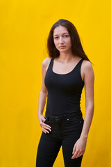 Obraz premium vertical photo of a Caucasian woman looking at camera, on yellow plain background