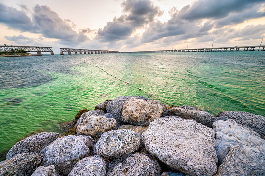 Old Seven Mile Bridge railroad road landscape of Florida Keys by Atlantic ocean water in Bahia Honda park beach at sunset by overseas highway US route 1 with rocks