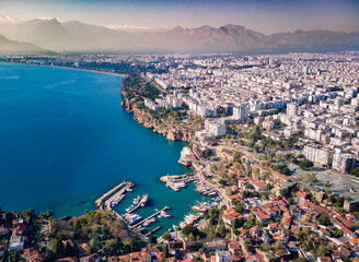 Naklejka premium Aerial photograph of Antalya bay in Antalya city from high point of drone fly on sunny day in in Turkey. Amazing aerial cityscape view from birds fly altitude on beautiful town and sea full of yahts