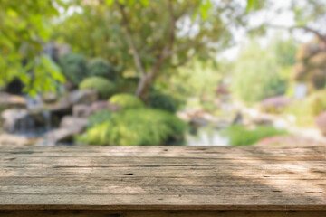 Empty wood table top with abstract blur park garden pond background
