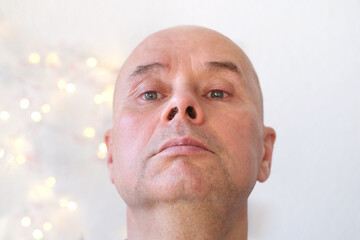 face of an elderly bald man close-up, senor looks, turns his head, thinks, dreams of a good, concept spring, good mood