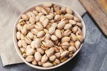 Ceramic bowl with pistachio nuts on linen tea towels
