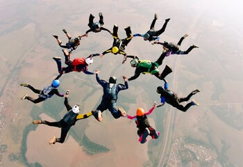 Skydivers holding hands making a fomation. High angle view. - 421086283