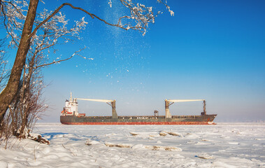 Winter shipping. Big cargo ship in frozen ice sea