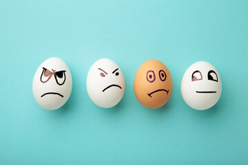 Eggs with different emotions on his face. Easter composition with copy space on blue background....