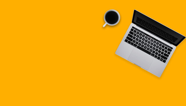 Top view of workspace with laptop, cup of coffee and copy space on colored background