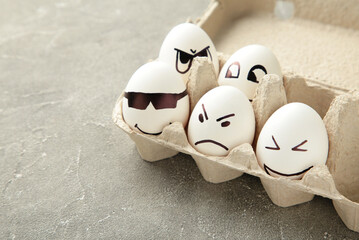 Eggs with different emotions on his face. Easter composition with copy space on grey background. Stop racism