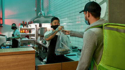 Delivery man picking up an order at a restaurant