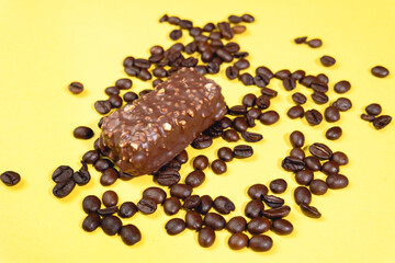 chocolate candy bar with coffee. on a yellow background, copy space