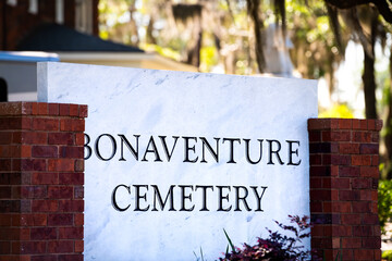 Closeup of Bonaventure cemetery historic sign in Savannah, Georgia with brick architecture and palm trees in blurry background in summer - Powered by Adobe